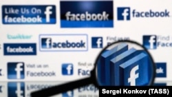 RUSSIA -- A magnifying glass in front of a computer screen showing Facebook logos - generic